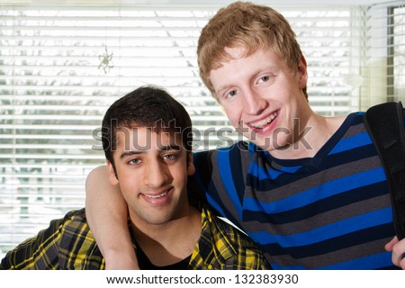 Two teenage friends in a casual pose, one leaning on the other.
