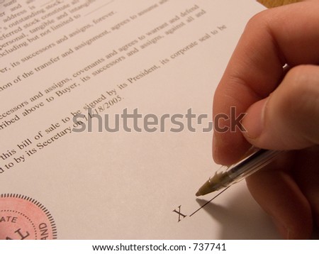 person\'s hand signing a contract bill of sale.