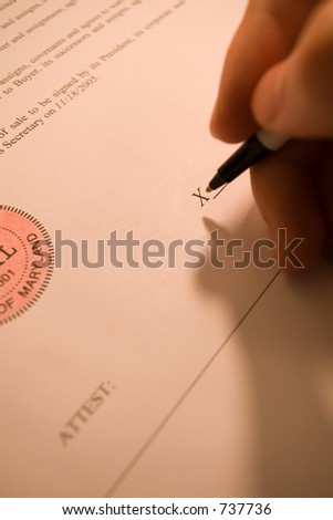 person\'s hand signing a contract bill of sale.