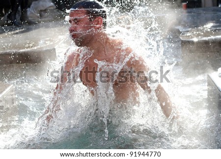 KHARKIV, UA - JANUARY 19: Unidentified Kharkov man swimming in ice cold water during Epiphany (Holy Baptism) in the Orthodox tradition, January 19, 2011 in Kharkov, Ukraine