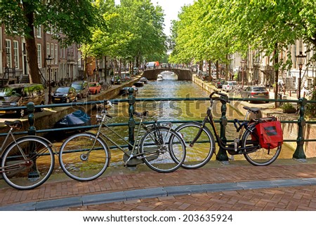 AMSTERDAM, NETHERLANDS - MAY 30: Bicycles on a bridge over the canal on May 30, 2014 in Amsterdam, Netherlands. Bikes are very popular in the Netherlands, the average Dane travels 900 km per year.