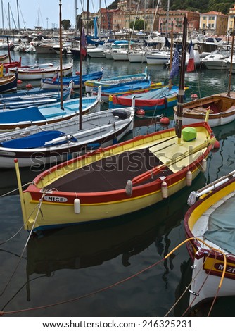 NICE, FRANCE - MAY 31, 2014: Colorful boats and buildings within a Port de Nice. Port de Nice was started in 1745.