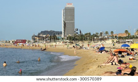 BARCELONA, SPAIN - JULY 5, 2015: Barceloneta Beach and skyscraper Torre Mapfre in the Olympic Port. It is named after its owner, Mapfre, an insurance company.