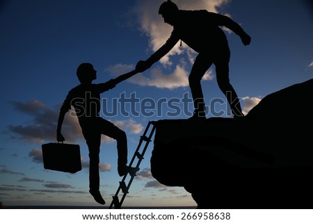 Teamwork of two men helping each other on top of mountain a career climbing team, concept of career ladder and teamwork