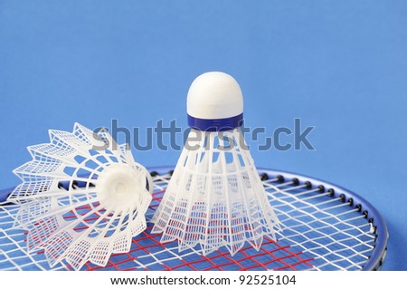 Badminton racket & shuttlecocks on blue background. Shallow Depth of Field