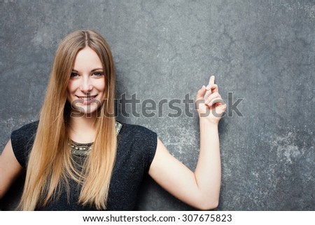 Attractive teenage girl pointing to the side