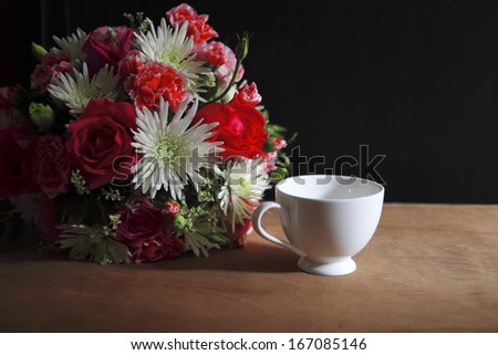 flower ,coffee cup and coffee beans on cork board