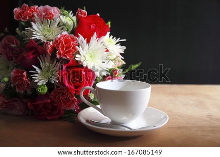 flower ,coffee cup and coffee beans on cork board