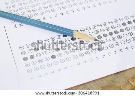 Standardized test form with answers bubbled in and a pencil, focus