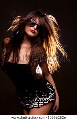 long hair brunette with sunglasses dancing, studio black background