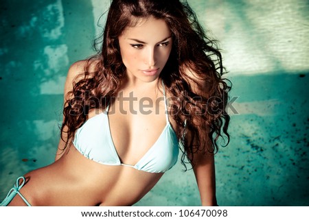 beautiful long hair young woman in bikini posing by the pool, outdoor portrait