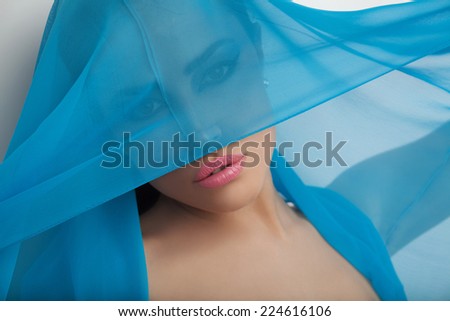 beautiful woman portrait with blue scarf over her head, studio white