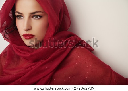 beautiful woman portrait with red lips and red veil over her head, studio shot