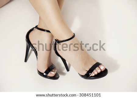 woman legs in stylish black heels, studio white