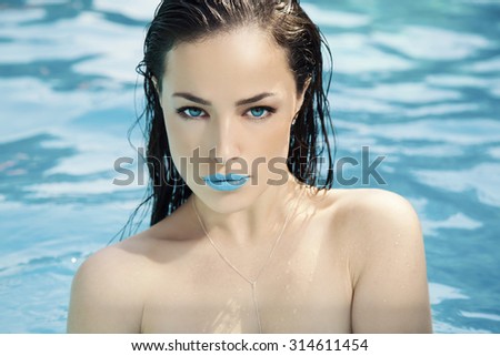 beautiful young woman portrait in pool, blue eyes and blue lipstick