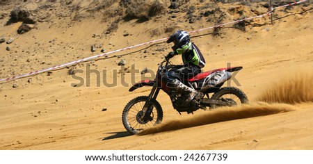 The sportsman on a motorcycle overcomes abrupt turn on a sandy line