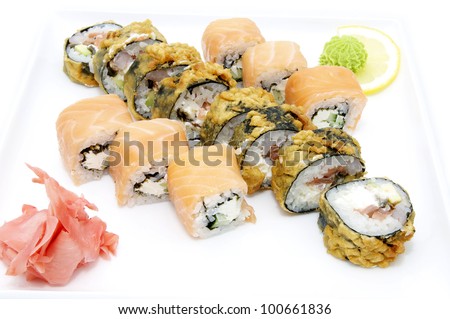 sushi and rolls on a white plate in a restaurant