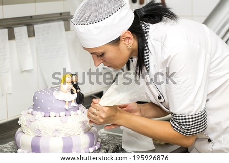 pastry chef decorates a cake in a candy store