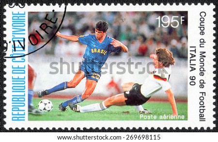 IVORY COAST - CIRCA 1990: stamp printed by Ivory Coast, shows Soccer players and ball, circa 1990.