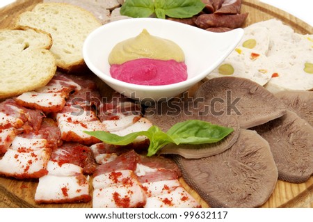 a plate of bacon and deli meats and sauce