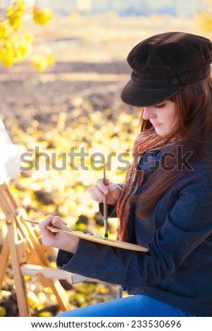 Woman artist with palette and brush in hand