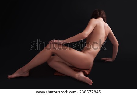 Beautiful back of young woman over dark background