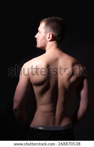 Rear view of a well-built bare-chested young man