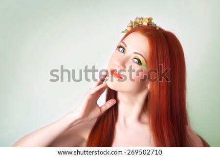 Portrait of beautiful red-haired girl with flowers in her hair and bright makeup