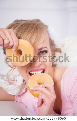 Portrait of attractive young charming woman with donuts in the hands