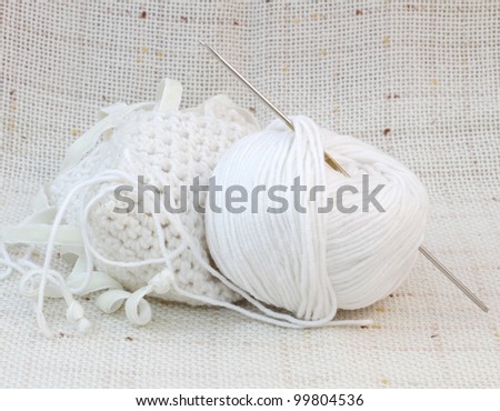 Close up of white ball (clew) of yarn and knitting hook