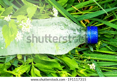 plastic bottle with water on a background of green grass
