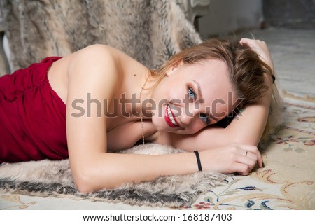 Young woman in red dress is lying on the floor