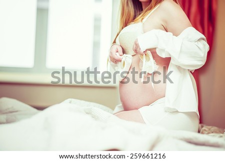 Pregnant woman in shape exposing belly
