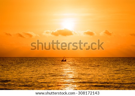 Beautiful sunset over the ocean with boat. Sunrise in the sea with silhouettes boat
