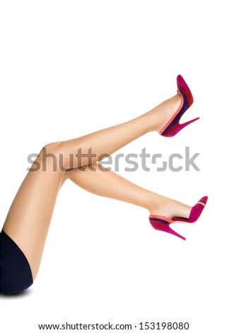 Smooth perfect female legs wearing high heels isolated on white background