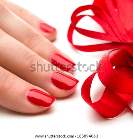 Woman hands with manicure red nails closeup and ribbon. Skin and nail care.