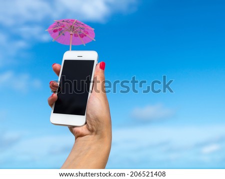 Woman hand showing mobile phone and cocktail umbrella on the sky in the background