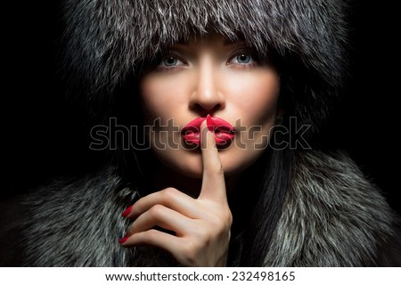 Fur Fashion. Beautiful Girl with red lips and manicure in Fur Hat. Winter Woman Portrait