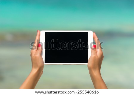 Concept of internet and communication. blank empty tablet computer in the hands of women on the beach