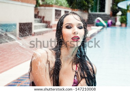 Wet woman by the pool in the yard