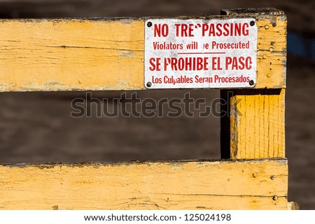 Worn No Trespassing, Violators will be Prosecuted in English and Spanish