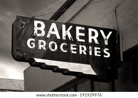 Black and White Worn Bakery and Groceries Sign in Small Town