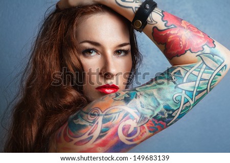 Young beautiful sexy brunette with gorgeous tattoo on her arms. tattoo