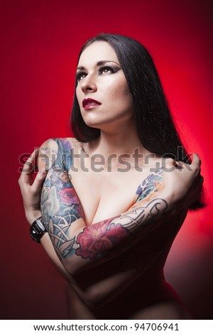 beautiful tattooed girl. red background.