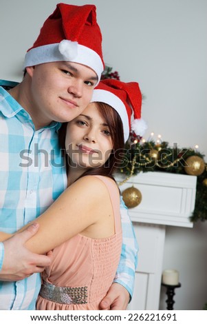Young happy couple hugging near New Year`s tree