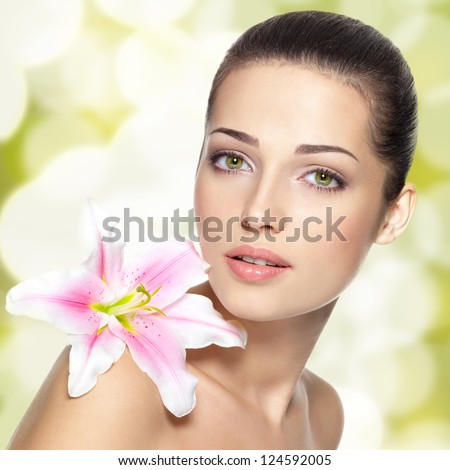 Beauty face of young woman with flower. Beauty treatment concept. Blinking Background. Bokeh