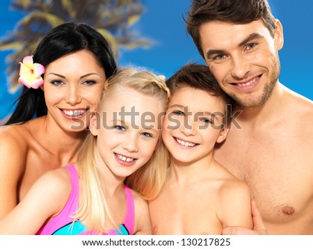 Portrait of  happy smiling beautiful family with two children at tropical beach