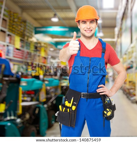 professional young worker with thumbs up sign at shop