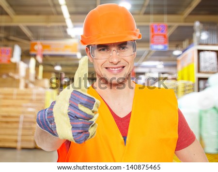 professional young worker with thumbs up sign at shop