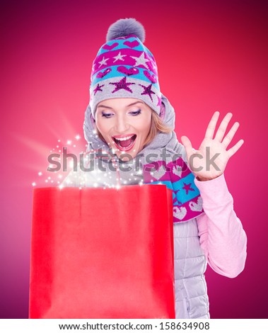 Photo of the happy surprised woman with gifts after shopping to the new year at shop